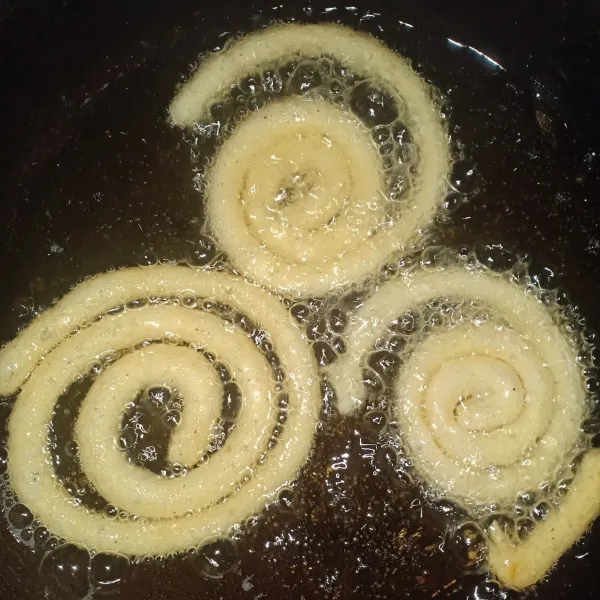 Panaskan minyak goreng, lalu tuang adonan kentang bentuk menyerupai spiral.