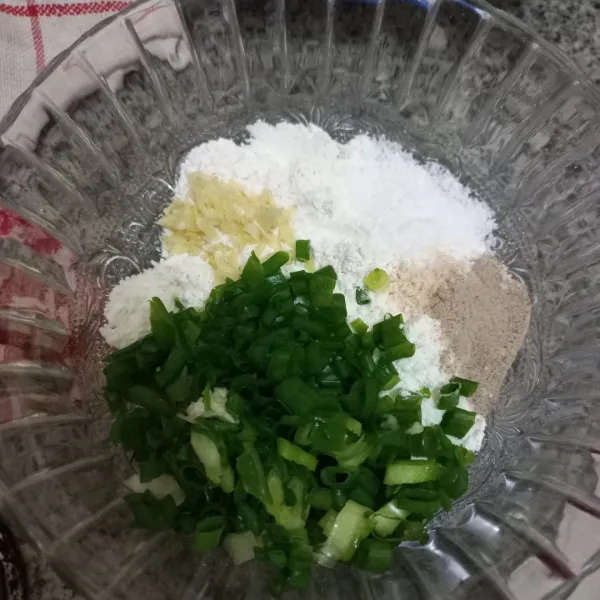 Dalam mangkuk campur tepung terigu, bawang putih, bawang daun, garam, kaldu jamur, dan merica bubuk, lalu aduk rata.
