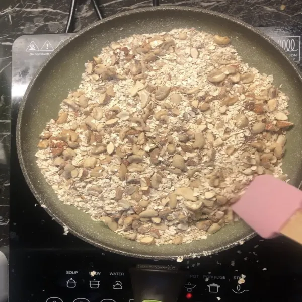 Sangrai kacang mete dan almond hingga hampir matang. Lalu tambahkan oatmeal. Sangrai hingga agak kering dan matikan kompor.