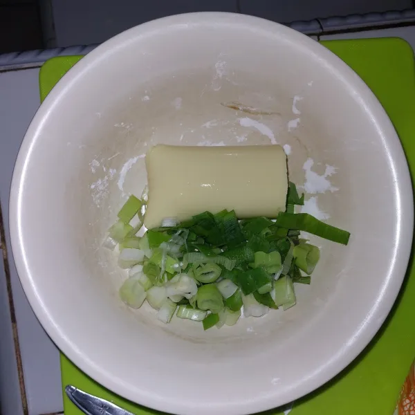 Masukkan tofu dan daun bawang yang sudah di cincang, lalu hancurkan dan aduk rata.