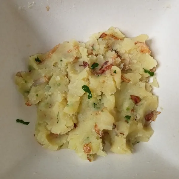Tambahkan bawang goreng, irisan seledri, garam, dan kaldu jamur ke dalam kentang, lalu aduk rata.