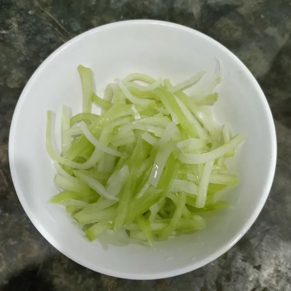 Potong memanjang labu Siam, lalu remas-remas menggunakan garam sampai lemas, kemudian cuci kembali sampai bersih.