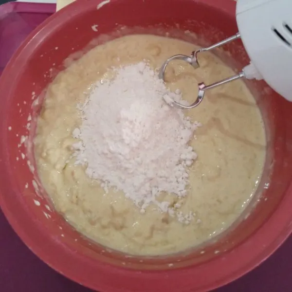 Kemudian masukkan tepung terigu, baking powder, garam, vanili, dan butter secara bertahap, aduk lagi dengan mixer menggunakan kecepatan sedang.