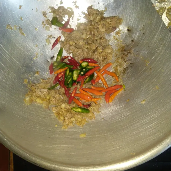Masukkan udang rebon dan irisan cabai merah keriting, cabai hijau dan cabai rawit utuh lalu aduk rata. Tumis sampai udang berubah warna.