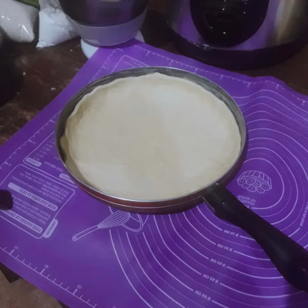 Kempiskan adonan dan bagi 2. Bulatkan dan pipihkan adonan. Olesi teflon dengan margarin, letakkan 1 adonan di atas teflon, tusuk - tusuk dengan garpu.