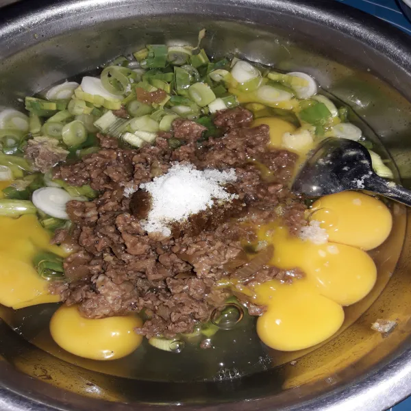 Kocok telur bersama dengan tumisan daging cincang, daun bawang, bumbu kare, dan garam.