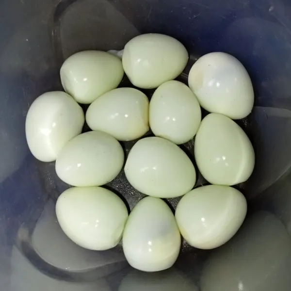 Rebus telur puyuh hingga matang, lalu kupas kulitnya.