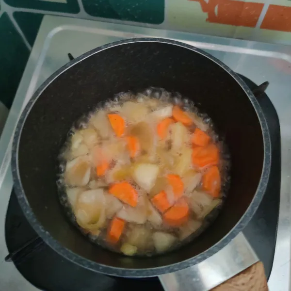 Tambahkan air, masak hingga wortel dan kentang matang.