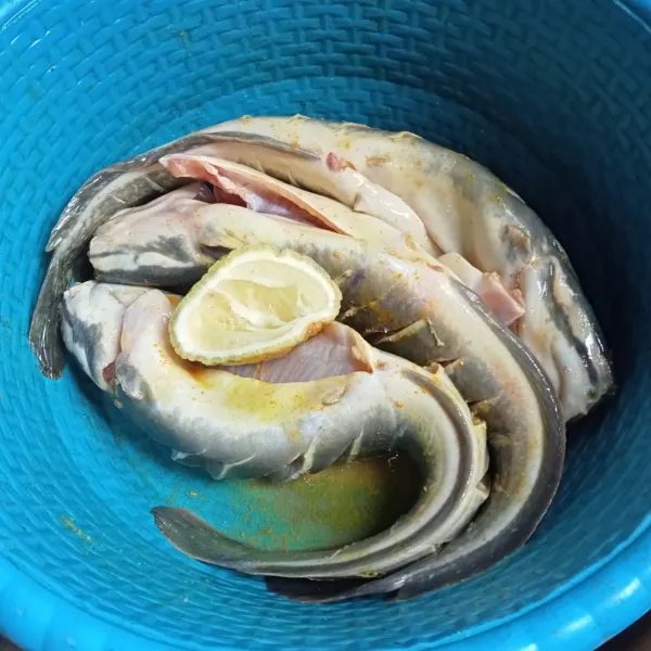 Marinasi ikan dengan bawang putih, kunyit bubuk, garam, kaldu jamur dan juga jeruk nipis.