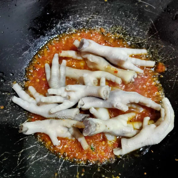 Masukkan ceker yang sudah direbus tadi, aduk rata lalu tambahkan sedikit air.