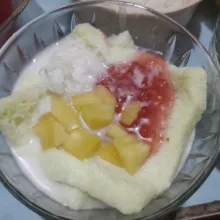 Tata bihun, sagu mutiara, dan potongan buah nangka di atas roti. Lalu ...