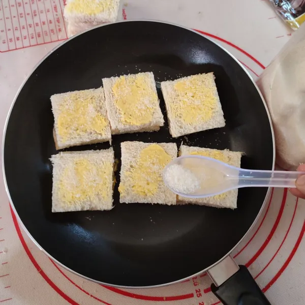 Kemudian, beri gula pasir secukupnya di kedua sisi roti.
