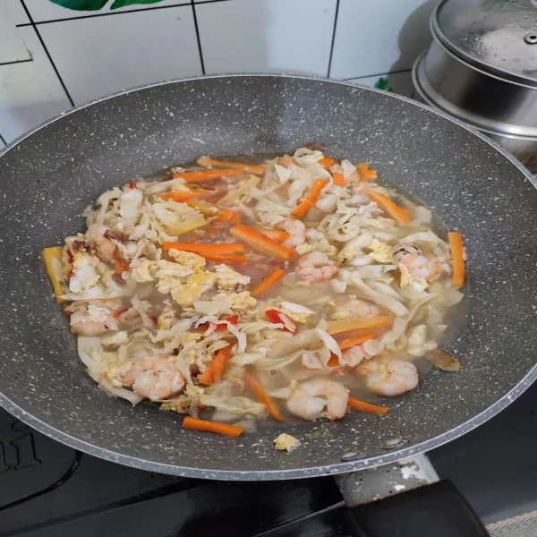 Masukkan wortel, kol, air, saos tiram dan garam. Masak hingga mendidih, dan sayur sedikit matang.