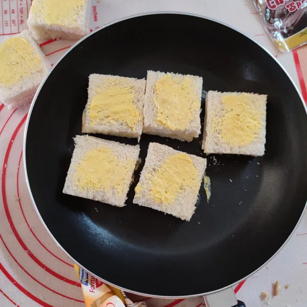 Oleskan margarine kedua sisi roti tawar.