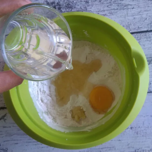 Tambahkan bawang putih, telur dan air. Aduk hingga tepung larut dan tidak bergerindil.