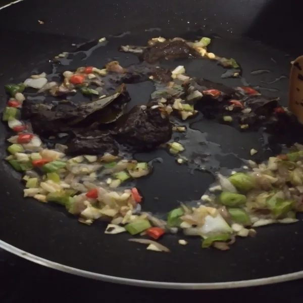 Masukkan bumbu rawon dan saos tiram, aduk rata, kecilkan api.