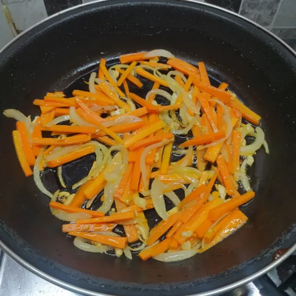 Masukkan irisan wortel, tumis sampai ½ matang.