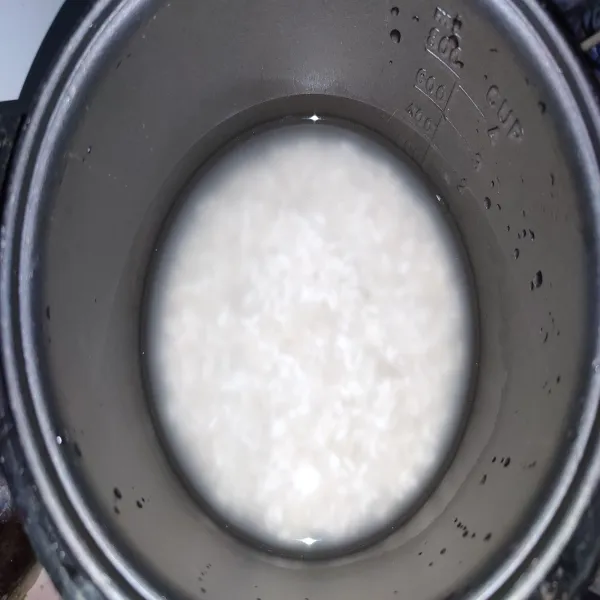 Cuci bersih beras dan beras ketan. Kemudian beri air. Masukkan ke dalam panci rice cooker. Tambahkan garam.