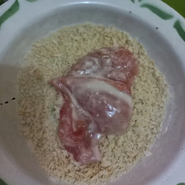 Gulingkan daging ayam pada tepung panir, tekan-tekan supaya tepung panir menempel pada ayam.