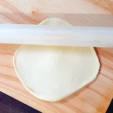 Ambil satu adonan, giling menggunakan rolling pin untuk mengeluarkan gas.