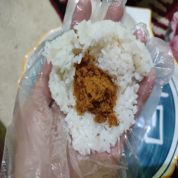 Bagi nasi menjadi 3 bagian, ambil satu bagian kemudian isi dengan abon.