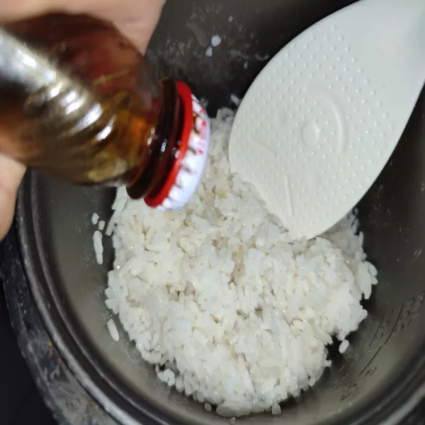 Setelah nasi matang, aduk-aduk nasi kemudian beri minyak wijen.