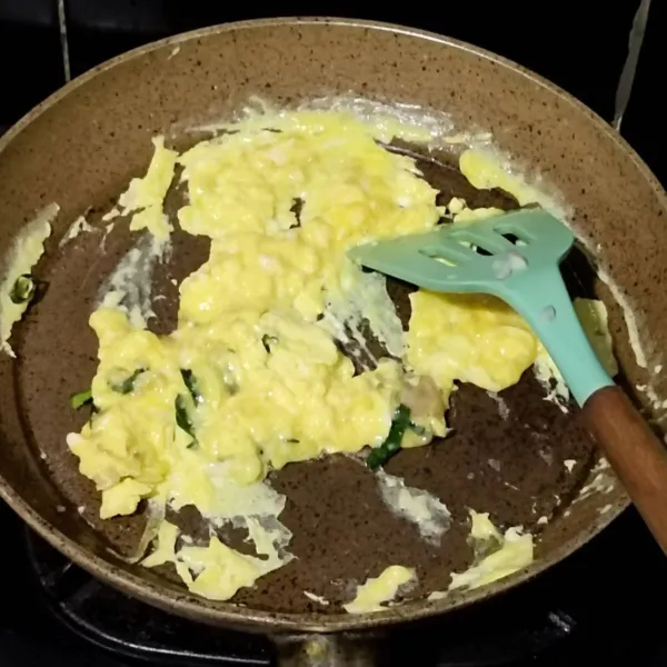 Panaskan sedikit minyak, lalu masukkan telur, daun jeruk, bawang daun, bawang putih bubuk, cabai bubuk, dan sejumput kaldu bubuk, lalu orak-arik telur.