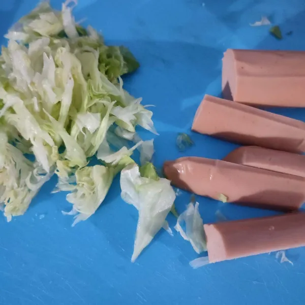 Bagi 2 sosis jumbo, kemudian bagi 4 setiap bagiannya. Iris tipis lettuce.