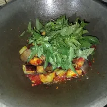 Masukkan terong dan kemangi, aduk-aduk hingga tercampur rata.