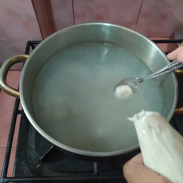 Cetak adonan cilok, langsung dimasukkan ke dalam air panas. Celupkan sendok ke air panas tiap kali akan mengambil adonan supaya tidak lengket.