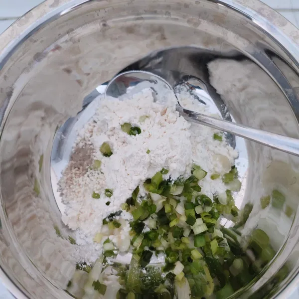Masukkan tepung terigu, irisan daun bawang, garam, merica bubuk dan kaldu jamur ke dalam mangkok. Aduk rata.