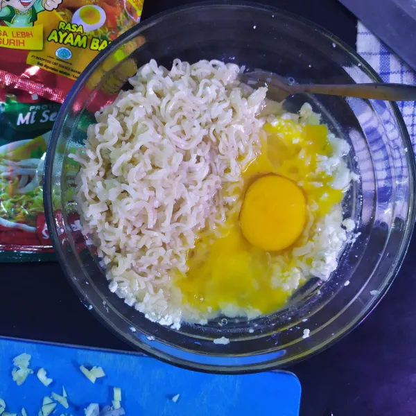 Lumatkan tahu dan bakso dengan garpu, masukkan mie dan juga telur.