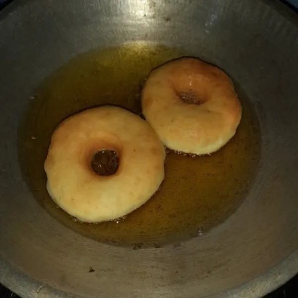 Panaskan minyak goreng dengam api sedang cendrung kecil, goreng donat dengan hanya sekali balik agar tidak meresap minyak. Setelah dingin taburi dengan gula donat.