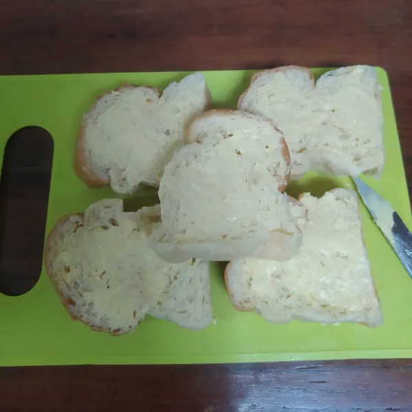 Oles kedua sisi roti tawar dengan margarin.