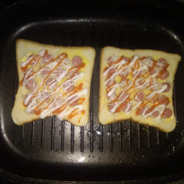 Panaskan teflon lalu lelehkan secukupnya margarin. Panggang pizza roti tawar sampai sisi bawah kecoklatan. Angkat lalu sajikan hangat.