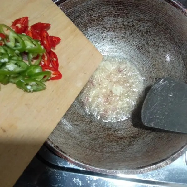 Tumis bawang putih dan bawang merah hingga harum, lalu masukkan cabai merah dan cabai hijau, masak sampai layu.