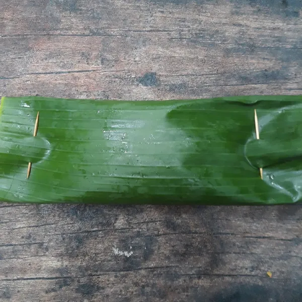 Gulung daun pisang lalu semat dengan tusuk gigi dikedua sisi gulungan daun pisang.
