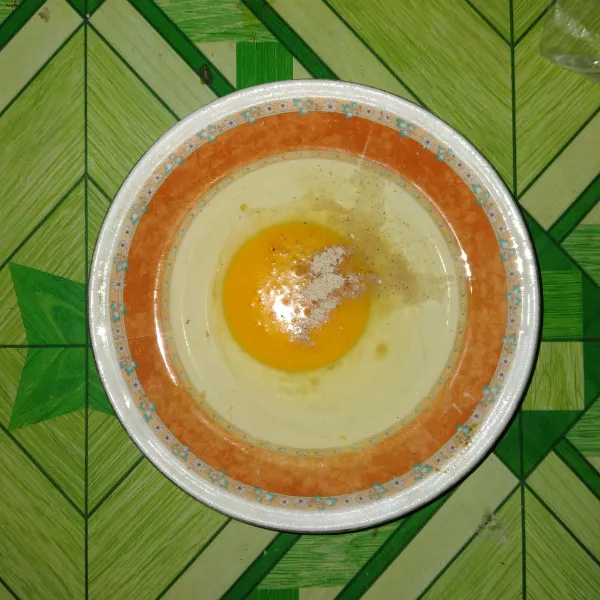 Kocok telur dengan diberi sejumput penyedap rasa.