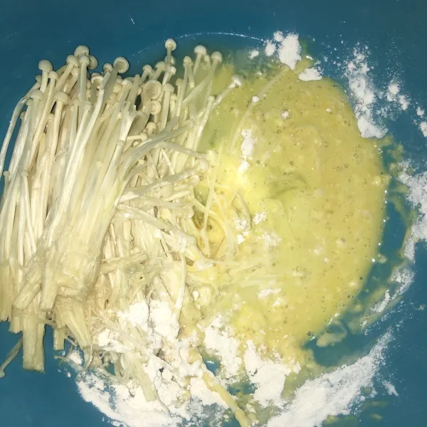 Celupkan enoki yang sudah dibersihkan kedalam tepung basah.