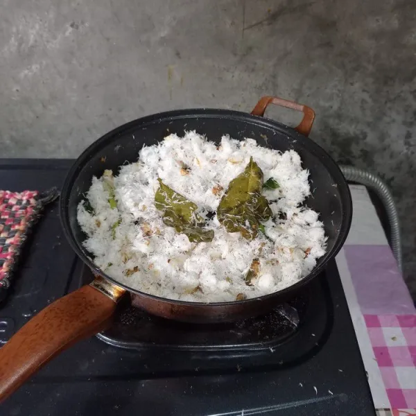 Gunakan api sedang.
Masukkan kelapa parut.