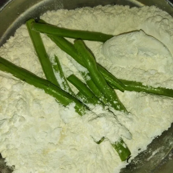 Lalu masukkan buncis secukupnya kedalam adonan tepung kering, aduk hingga buncis dilapisi tepung.