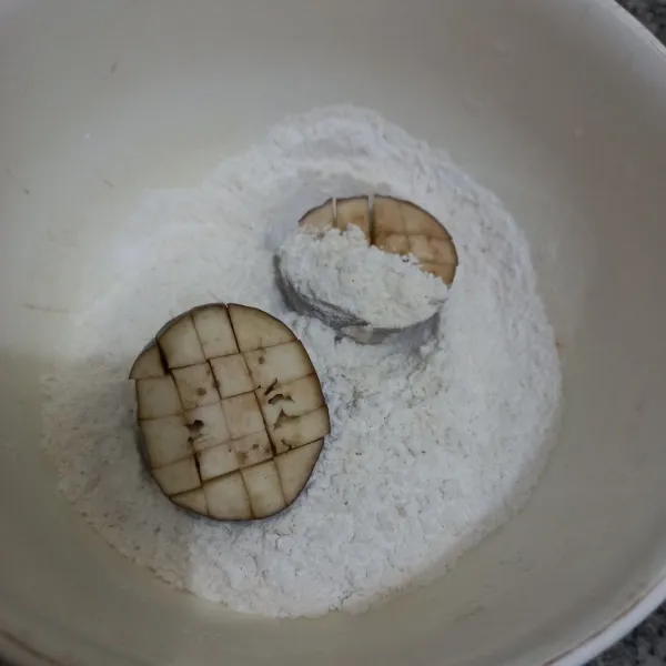 Masukkan terong ke dalam tepung, baluri hingga tepung meresap pada terong.