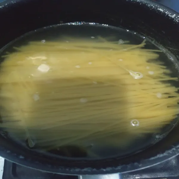 Siapkan panci. Beri air. Beri sedikit minyak goreng. Setelah mendidih, masukkan spaghetti. Masak sampai 1/2 matang saja. Setelah matang lalu diangkat. Sisihkan.