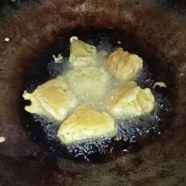 Celupkan tahu ke dalam bahan pencelup, lalu goreng di minyak panas hingga keemasan, angkat dan siap disajikan.