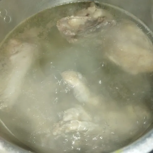 Lalu masak air hingga mendidih, masukkan daging dan buang buihnya.
Rebus daging ayam hingga setengah matang dengan api sedang cenderung kecil.