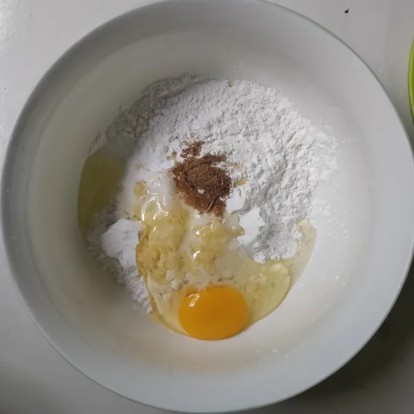 Masukkan tepung beras, tepung tapioka, telur, bawang putih bubuk, ketumbar, garam, kaldu jamur dan kunyit bubuk ke dalam wadah.