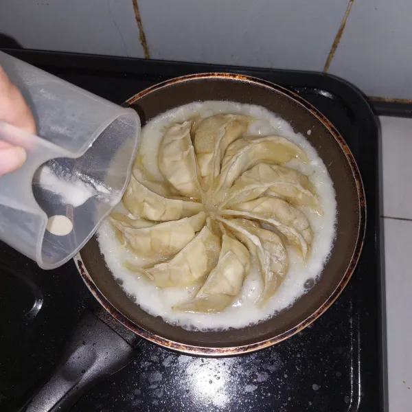 Masukkan campuran air dan terigu mengelilingi gyoza agar rata.