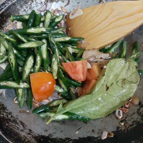 Masukkan cabai hijau, tomat, daun salam dan lengkuas, tumis sampai layu.