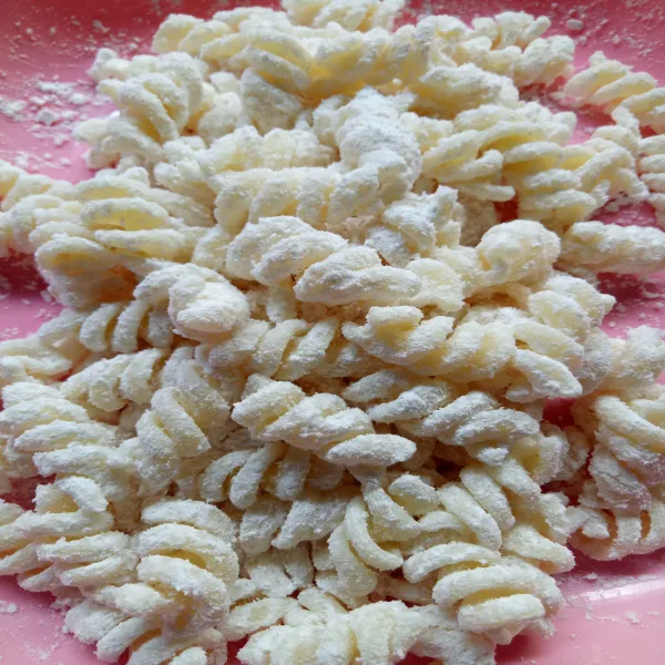 Beri tepung ke dalam macaroni lalu aduk hingga tercampur rata.