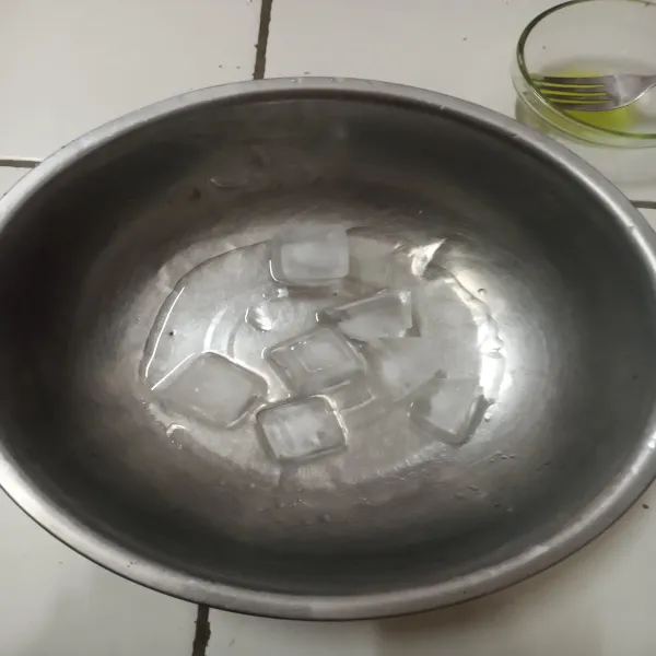 Siapkan wadah, lalu masukkan 15 ml air dan es batu.